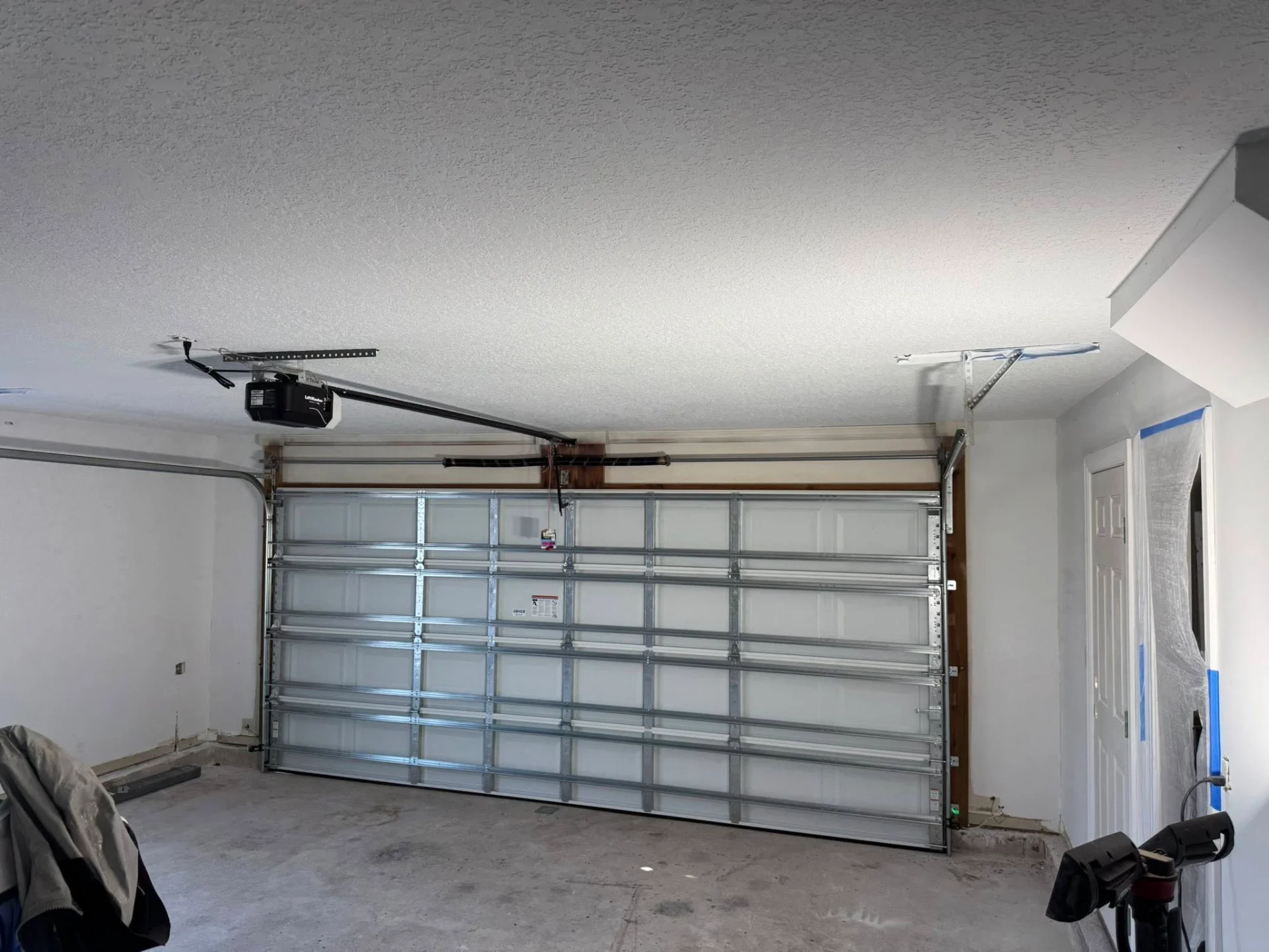 Garage door interior view showing steel reinforcement struts and opener mechanism
