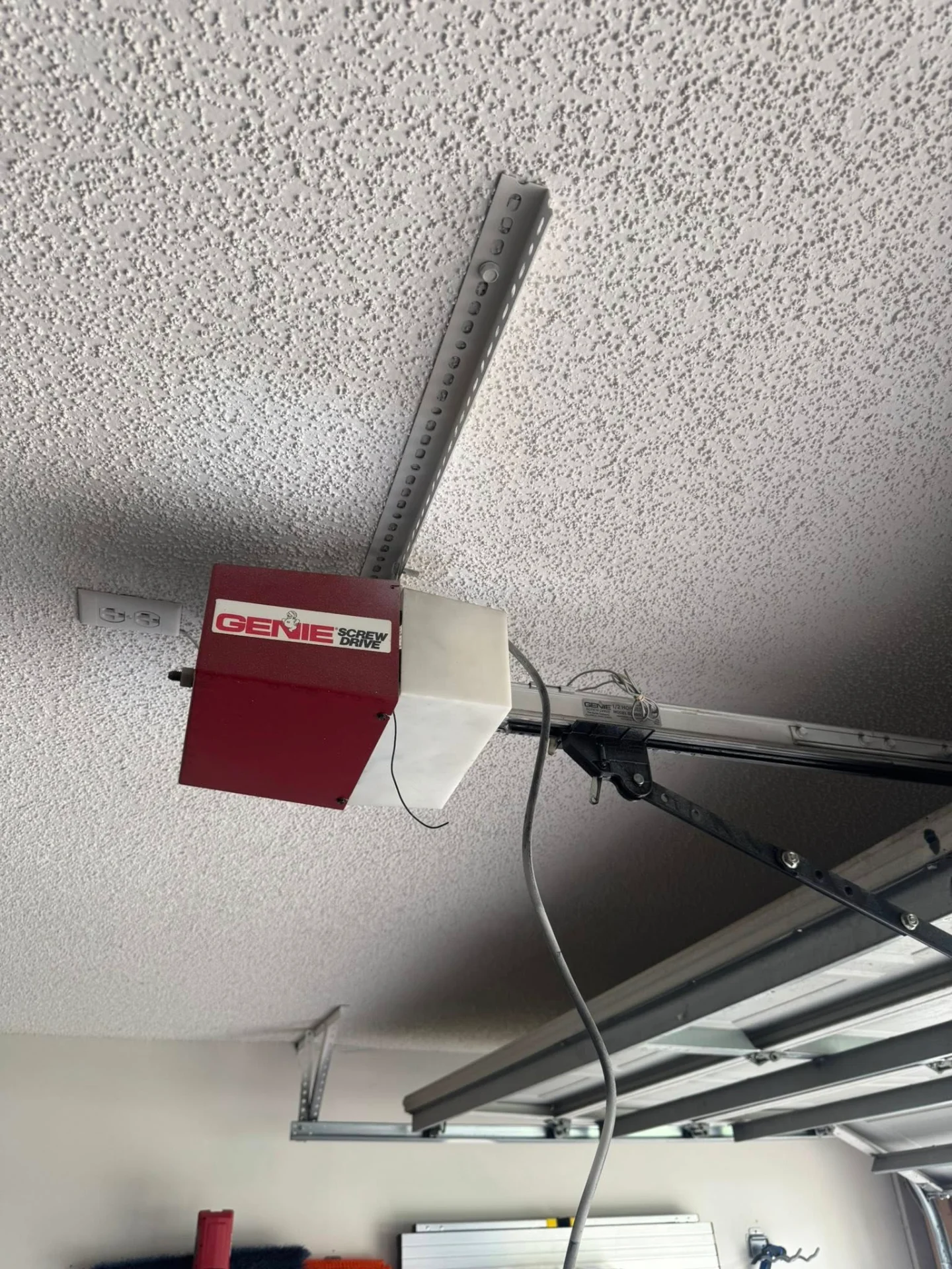 Red Genie Screw Drive garage door opener motor mounted on ceiling