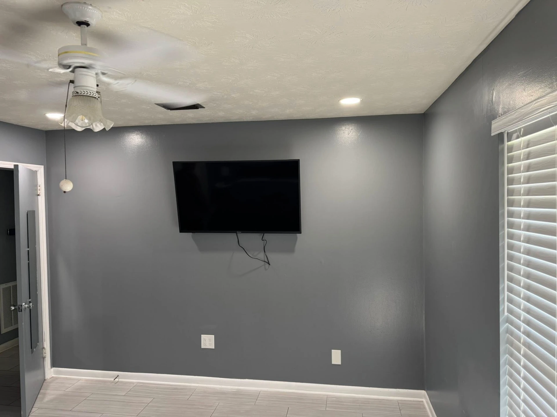 Finished room with TV mount, ceiling fan, and recessed lighting